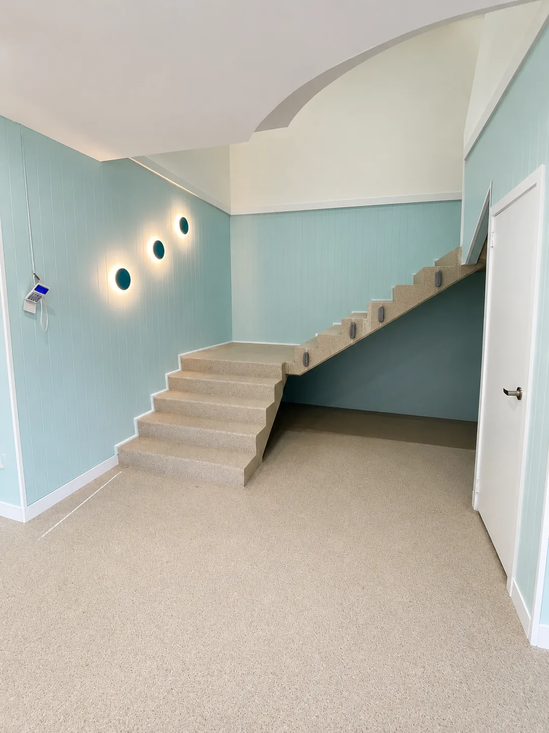 Internal staircase with soft teal feature walls, recessed round wall niches and a clean white ceiling, painted by Paint Gods.